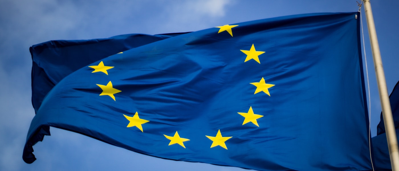 Drapeau européen flottant, symbole du règlement européen sur l’intelligence artificielle