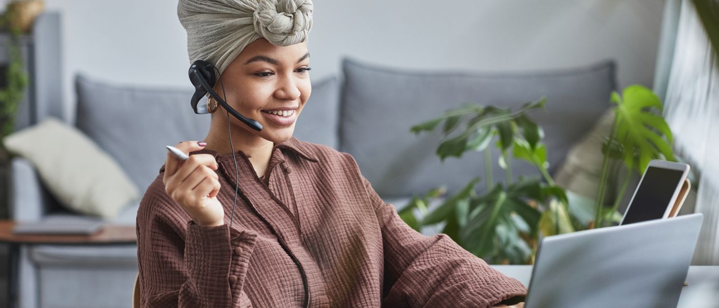 Assistante travaillant à distance avec un casque téléphonique et un ordinateur portable